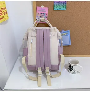 Detail showing beige and purple canvas backpack back with padded straps and side pockets