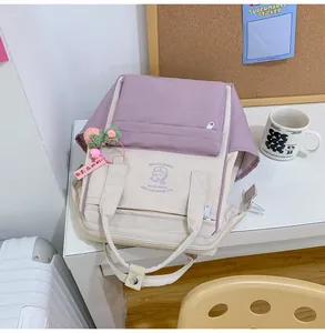 Detail of color-block canvas backpack with pastel purple design and floral charm