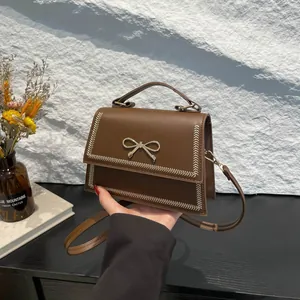 Bolso bandolera de cuero PU marrón con lazo metálico dorado y costuras en forma de V