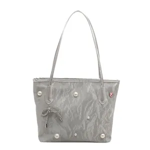 Silver tote bag with pleated texture, pearl accents, and metallic bow for women