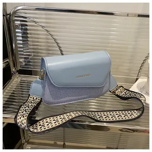 Detail of light blue crossbody bag with fashion & bags logo and geometric wide strap
