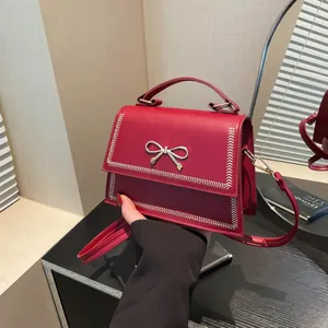 Bolso de mano rojo de cuero con hebilla de lazo plateado y costuras blancas decorativas