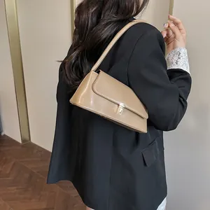 Chic khaki baguette shoulder bag with gold clasp shown on a model in a black blazer