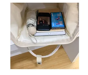 Top view of small cream backpack interior holding tablet, umbrella, and power bank