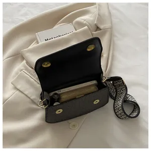 Detail view of herringbone crossbody bag interior showing spacious storage with wide strap
