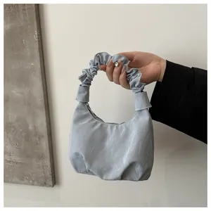 Gros plan du sac nuage bleu clair avec poignée plissée et texture en nylon soyeux