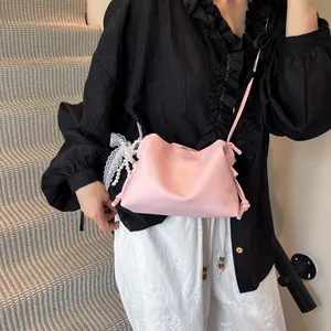 Pink dumpling bucket bag with lace pearl charms and thin leather strap for spring