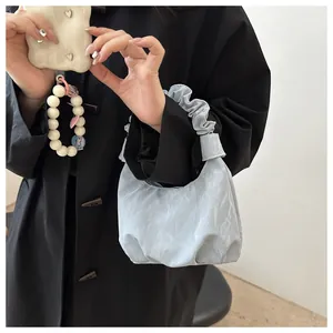 Vue détaillée du sac hobo bleu clair avec poignée froncée et texture plissée