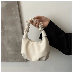 Vue détaillée du sac à main blanc crème avec poignée froncée et texture plissée chic