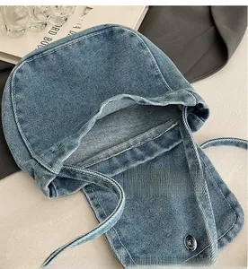 Detail view of the spacious inner compartment and magnetic closure of the denim bag