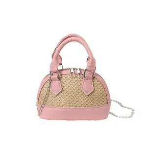 Pink woven patchwork shell crossbody bag with leather handles and silver chain strap