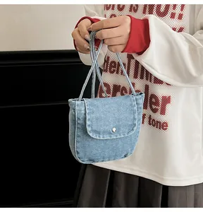 Detailed view of light blue denim mini bag with silver buckle and woven texture