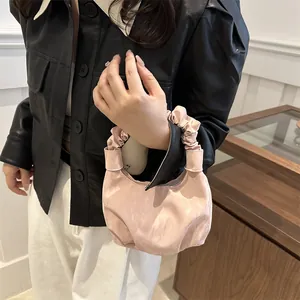 Sac à main plissé rose avec poignée froncée et forme de croissant sur modèle