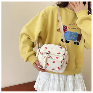 Detail of corduroy crossbody bag with strawberry print and front zipper pocket
