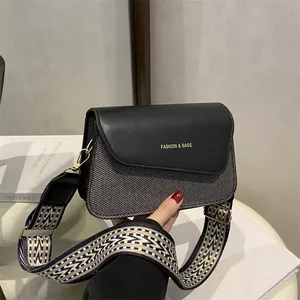 Fashionable crossbody bag featuring grey herringbone fabric and ethnic style wide strap
