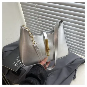 Minimalist silver underarm bag with golden chain strap and metallic leather finish