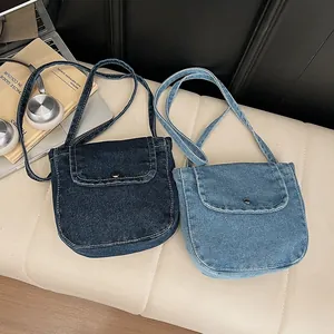 Retro denim crossbody bag in dark and light blue wash with stylish metal snap button