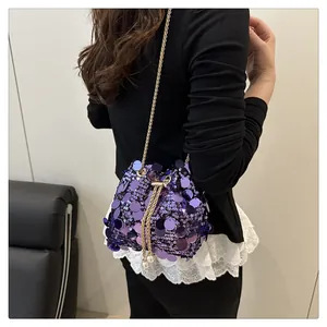 Detail of purple sequin bucket bag with golden chain and pearl drawstrings