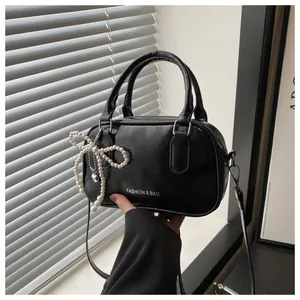 Sac bowling noir chic avec finition brillante et breloque nœud perlé pour femme