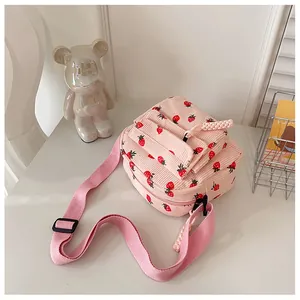 Detailed shot of pink corduroy crossbody bag with strawberry print and adjustable strap