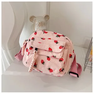 Detailed texture of pink corduroy crossbody bag with strawberry prints and braided zipper