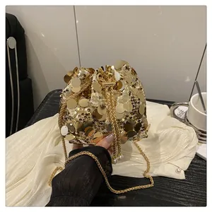 Detail of gold sequin bucket bag with pearl drawstring and metal chain strap