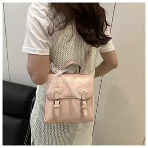 Detail of pink PU backpack showing back profile, lace bow, and cat-ear bow textures