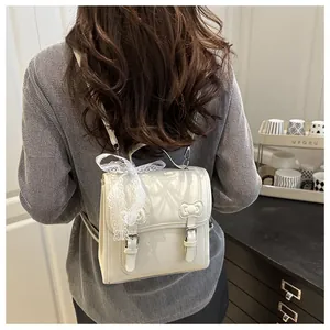 Detail of cream PU backpack featuring a decorative bow and lace strap on the handle