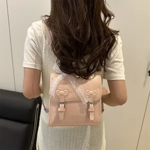 Pink PU leather backpack with bow accents and lace ribbon shown on model back