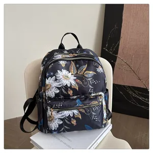 Rugzak met bloemenprint, witte madeliefjes en blauwe vogels op zwart nylon materiaal
