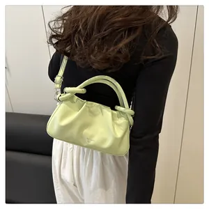 Détail du sac nuage plissé vert clair avec texture cuir et inscription embossée