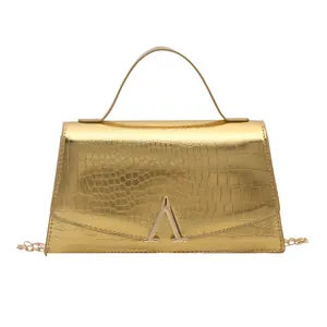 Chic gold crocodile-embossed handbag with trapezoid shape and metallic chain strap