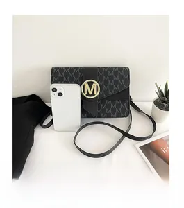 Size comparison of a black patterned crossbody bag with a smartphone and metal logo