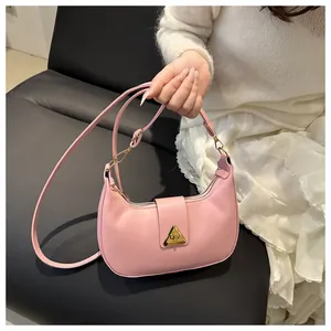 Pink crescent underarm bag detail featuring a unique gold triangle buckle and smooth leather