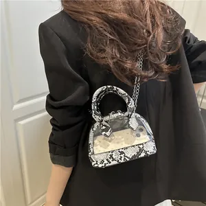 Borsa a conchiglia in PVC trasparente con finiture a serpente e tracolla a catena