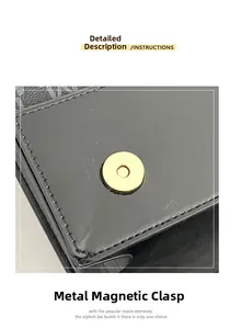 Detail of the golden magnetic hardware clasp on a black textured leather crossbody bag
