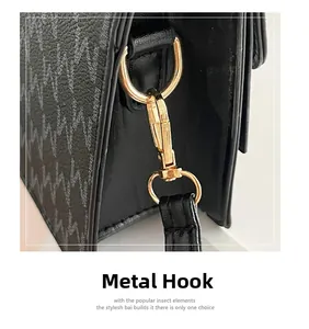 Detail of premium gold-toned hardware hook and textured leather strap on a black bag