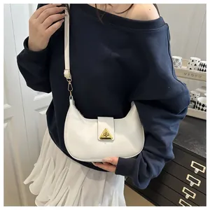 Detail view of white crescent hobo bag with iconic gold triangle buckle on model