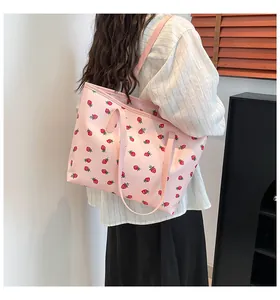 Vue détaillée d'un sac cabas rose avec imprimé fraises et une fine bandoulière élégante