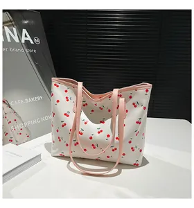 Détail d'un grand sac cabas avec imprimé cerise et élégantes bandoulières de couleur rose