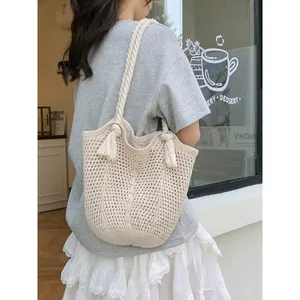 Grand sac cabas tressé beige avec poignées en corde et pompons pour les vacances à la plage