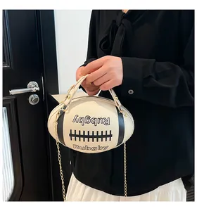 Dettaglio della borsa a tracolla a forma di rugby con catena e manico in finitura bianco crema