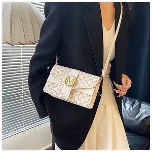 Detail view of white crossbody bag featuring gold metal buckle and all-over letter print