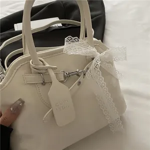 Gros plan détaillé du sac en cuir PU crème avec décoration élégante en nœud de dentelle