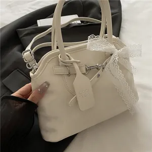 Détail d'un sac crème avec noeud en dentelle délicat et texture de cuir raffinée