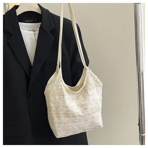 Detailansicht des filigranen Blumen-Spitzenmusters einer cremefarbenen Shopper-Tasche