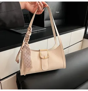 Dettaglio borsa sottobraccio crema effetto coccodrillo con fibbia d'oro e foulard