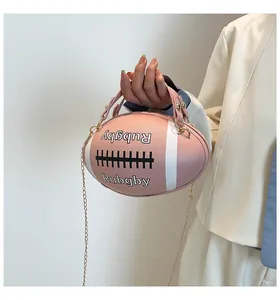 Dettaglio della borsa a mano rosa a forma di rugby con manico in pelle e catena d'oro