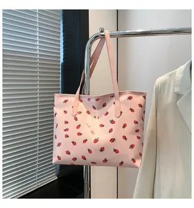 Vue détaillée du sac cabas rose avec imprimé fraise suspendu sur un support