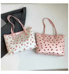 Vue détaillée de grands sacs cabas aux imprimés cerise et fraise avec anses roses